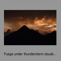 Fuego under thunderstorm clouds at sunset
